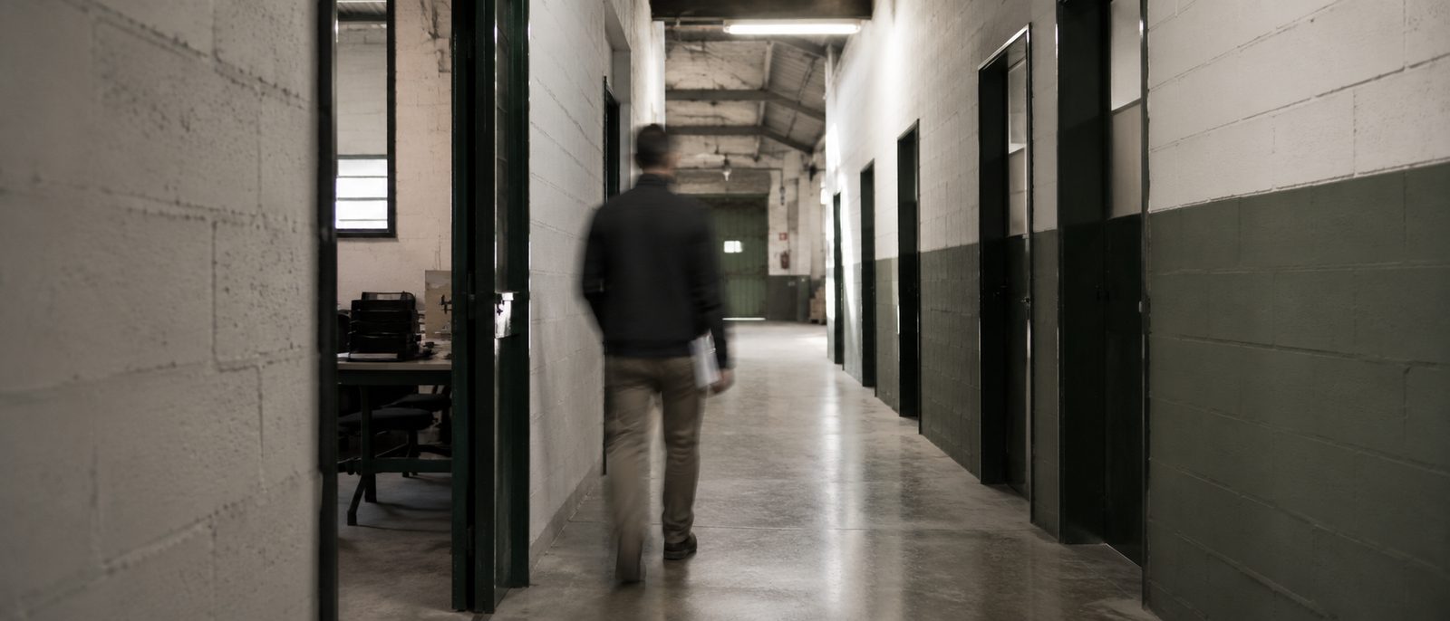 Persona cruzando un pasillo industrial con decisión